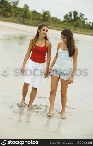 Two girls standing on the beach