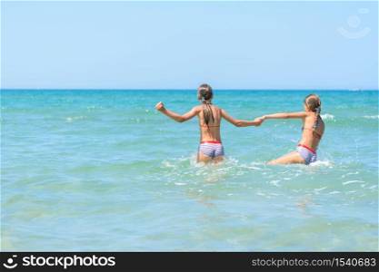 Two girls swim in the sea on a hot day