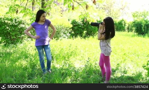 Two girls taking pictures in the city park