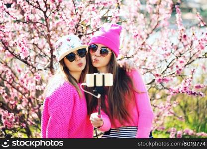 Two girls taking selfie with mobile phone