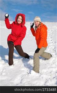 two girls throw snowballs