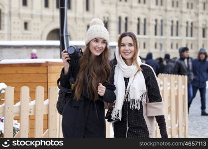 Two girls tourists are photographed in Moscow (Russia) winter 2015