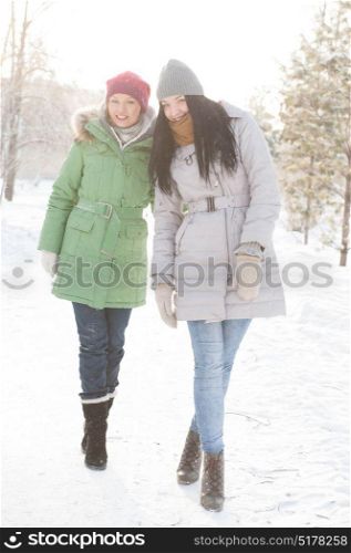 Two girls walk in the forest covered in snow