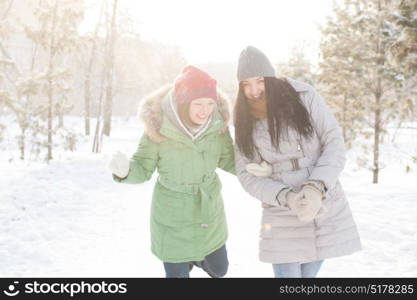 Two girls walk in the forest covered in snow