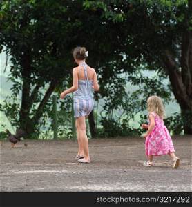 Two Girls Walking with Backs to Camera at Moorea in Tahiti