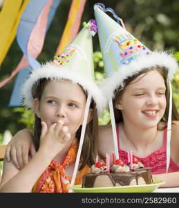 Two girls wearing party hats on a birthday