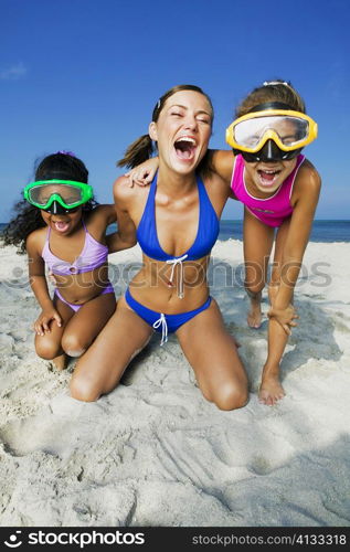 Two girls with a young woman playing on the beach