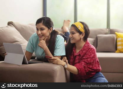 Two girls with laptop and  credit card shopping online. 