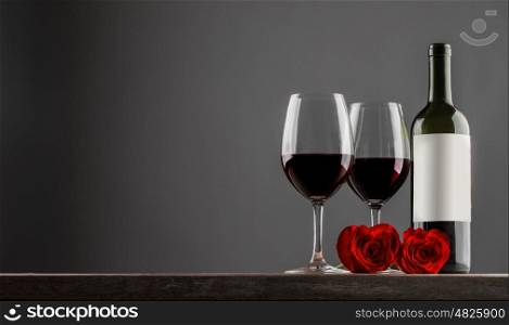 Two glasses and bottle of red wine, heart shaped roses, Valentine day