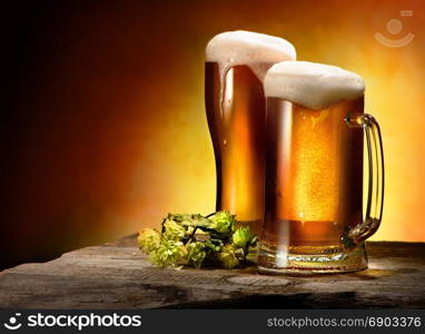 Two glasses of beer and hops on the table