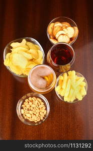 Two glasses of beer with various snacks