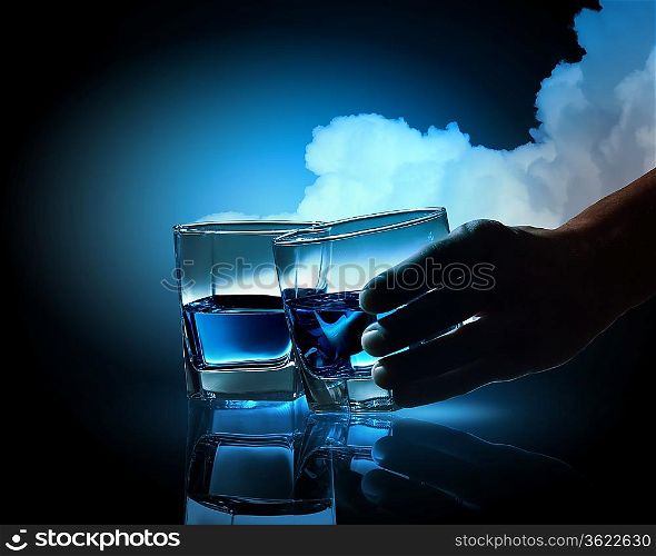 Two glasses of blue liquid against cloudy background