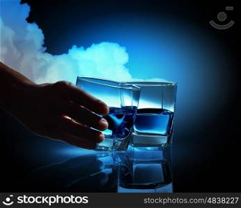 Two glasses of blue liquid. Two glasses of blue liquid against cloudy background