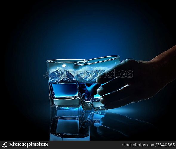 Two glasses of blue liquid with mountain illustration in