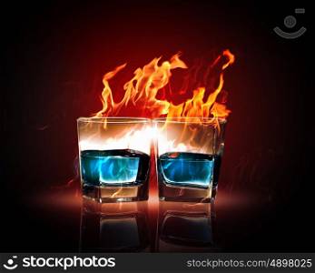 Two glasses of burning emerald absinthe. Image of two glasses of burning emerald absinthe