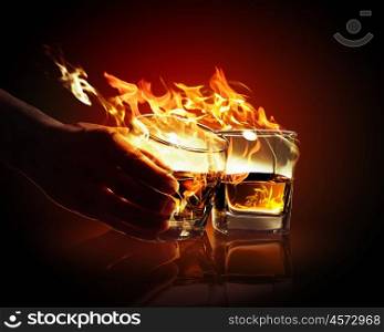 Two glasses of burning yellow absinthe. Image of two glasses of burning yellow absinthe