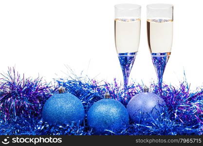 two glasses of champagne at blue and violet Christmas balls and tinsel isolated on white background