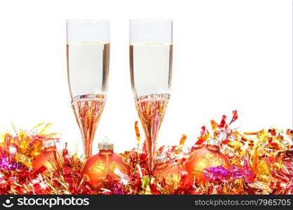 two glasses of champagne at red and orange Christmas balls and tinsel isolated on white background