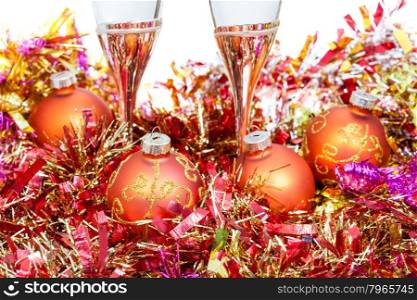 two glasses of champagne at yellow and orange Christmas decorations close up isolated on white background
