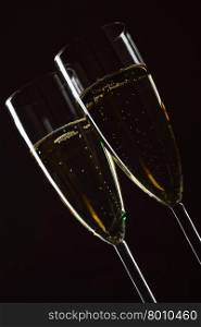 Two glasses of champagne close-up over black background