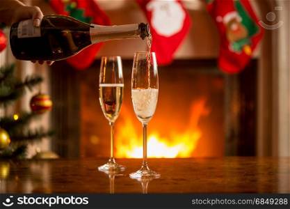 Two glasses of champagne next to the fireplace