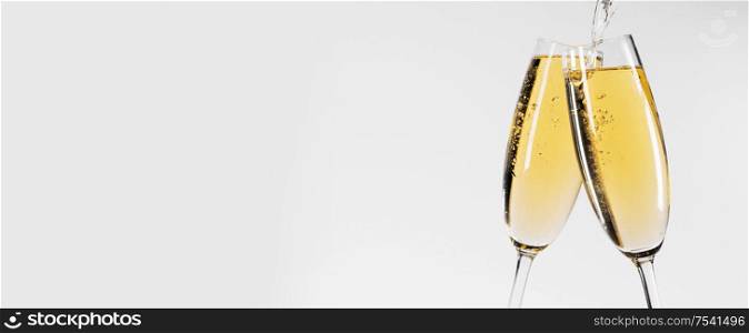 Two glasses of champagne on white background, pouring wine. Two glasses of champagne