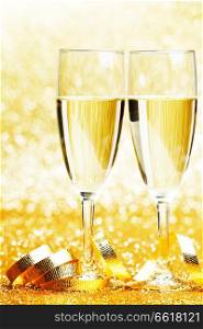 Two glasses of champagne with bow on golden background
