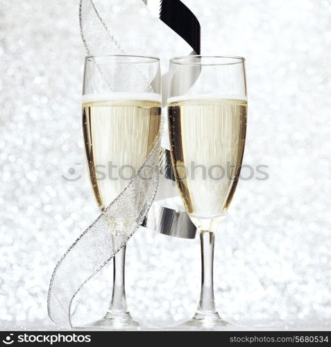 Two glasses of champagne with bow on silver background