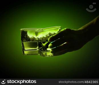 Two glasses of green absinth. Two glasses of green absinth with nature illustration in