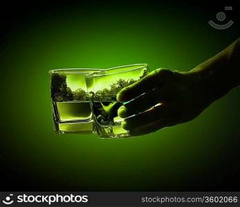 Two glasses of green absinth with nature illustration in