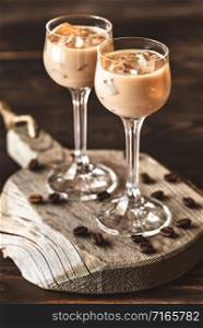 Two Glasses Of Irish Cream Liqueur On The Wooden Board