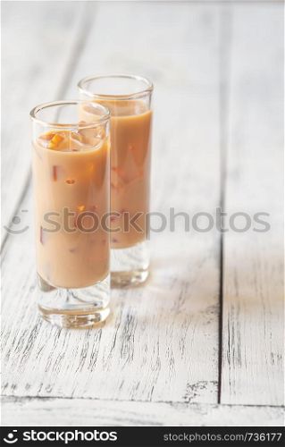 Two Glasses Of Irish Cream Liqueur On The Wooden Table