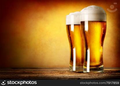 Two glasses of lager on a wooden table