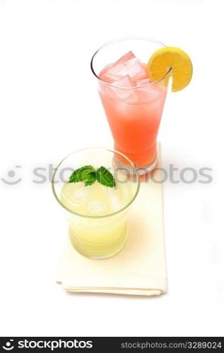 Two glasses of lemonade, one pink and the other yellow with a slice of lemon and a sprig of mint leaf.. Lemonade