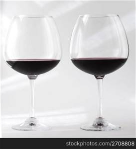 Two glasses of red wine over white background