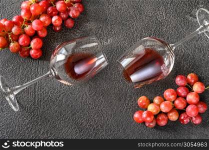 Two glasses of red wine with bunch of grapes: top view