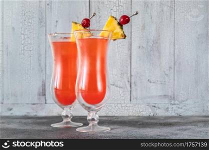 Two glasses of Singapore Sling on wooden background
