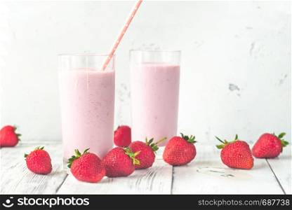 Two glasses of strawberry shake with fresh strawberries