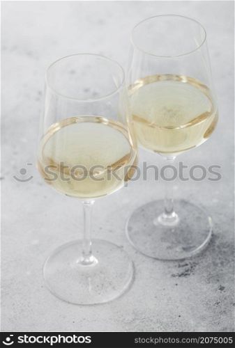 Two glasses of white homemade summer refreshing wine on light stone background.