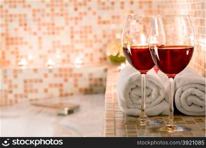 two glasses of wine and burning candles close-up in the bathroom