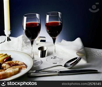 Two glasses of wine beside a plate of prawns