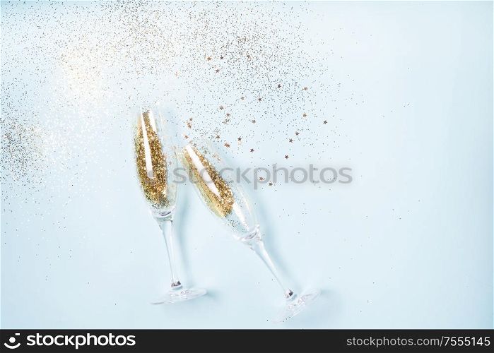 Two glasses with Christmas amd Happy New Year Champagne over blue background. Christmas amd Happy New Year Champagne