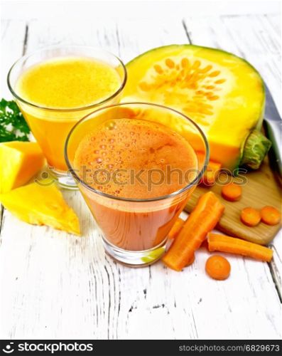 Two glasses with pumpkin and carrot juice, vegetables, a knife on the background of a light wooden board