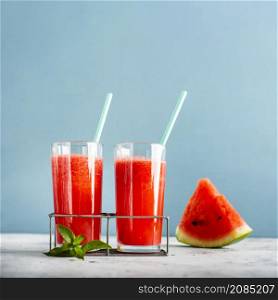 two glasses with watermelon juice slice beside