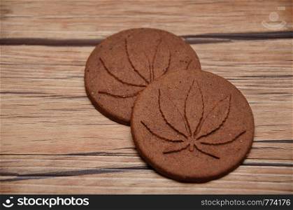 Two golden brown cannabis biscuits with cannabis leave prints