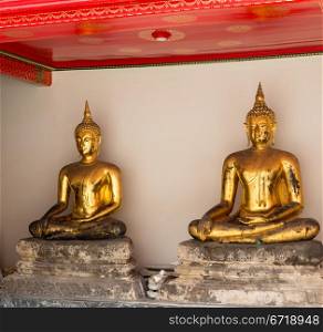 Two golden buddha statues in Wat Po temple near Bangkok in Thailand