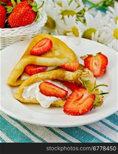 Two golden pancakes with strawberries and cream, a basket of berries, bouquet of daisies on a striped linen napkin