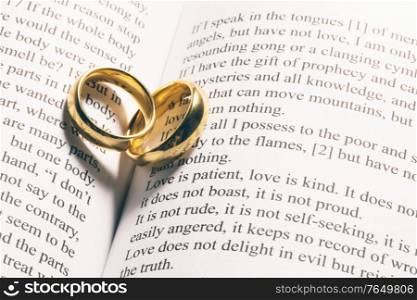 Two golden wedding rings on Holy bible book close up. Golden wedding rings on bible book
