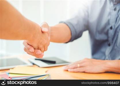 Two Graphic designer handshake Meeting and drawing on graphics tablet at workplace