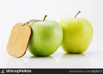 two green apple with tag isolated on white background